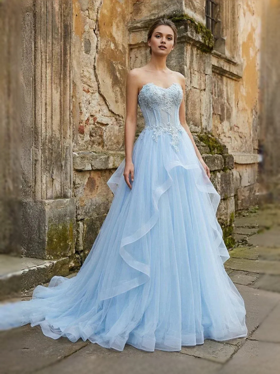 Light blue strapless sweetheart tulle ball gown with corset bodice and tiered skirt