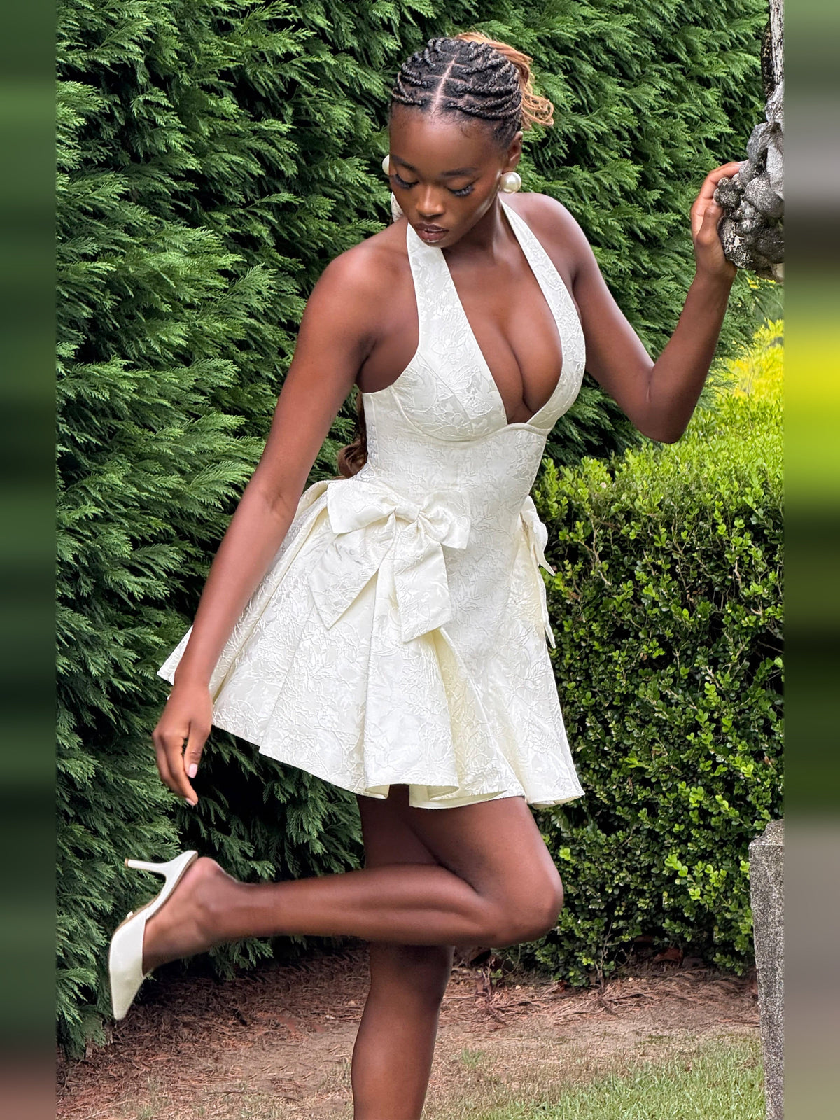 Ivory halter mini dress with bow waist detail and textured, flared skirt