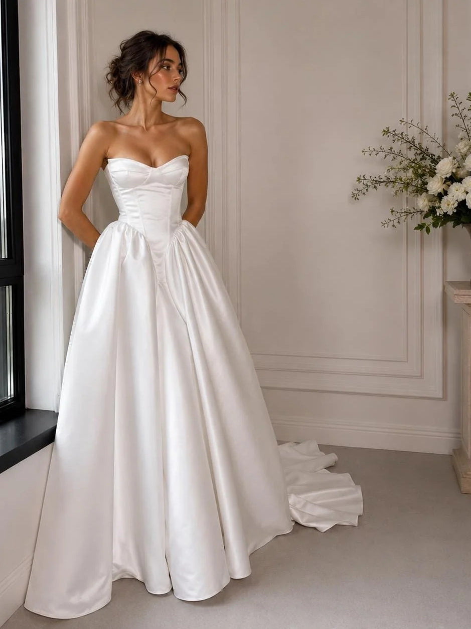 Ivory satin strapless sweetheart corset wedding dress with gathered skirt and long hem