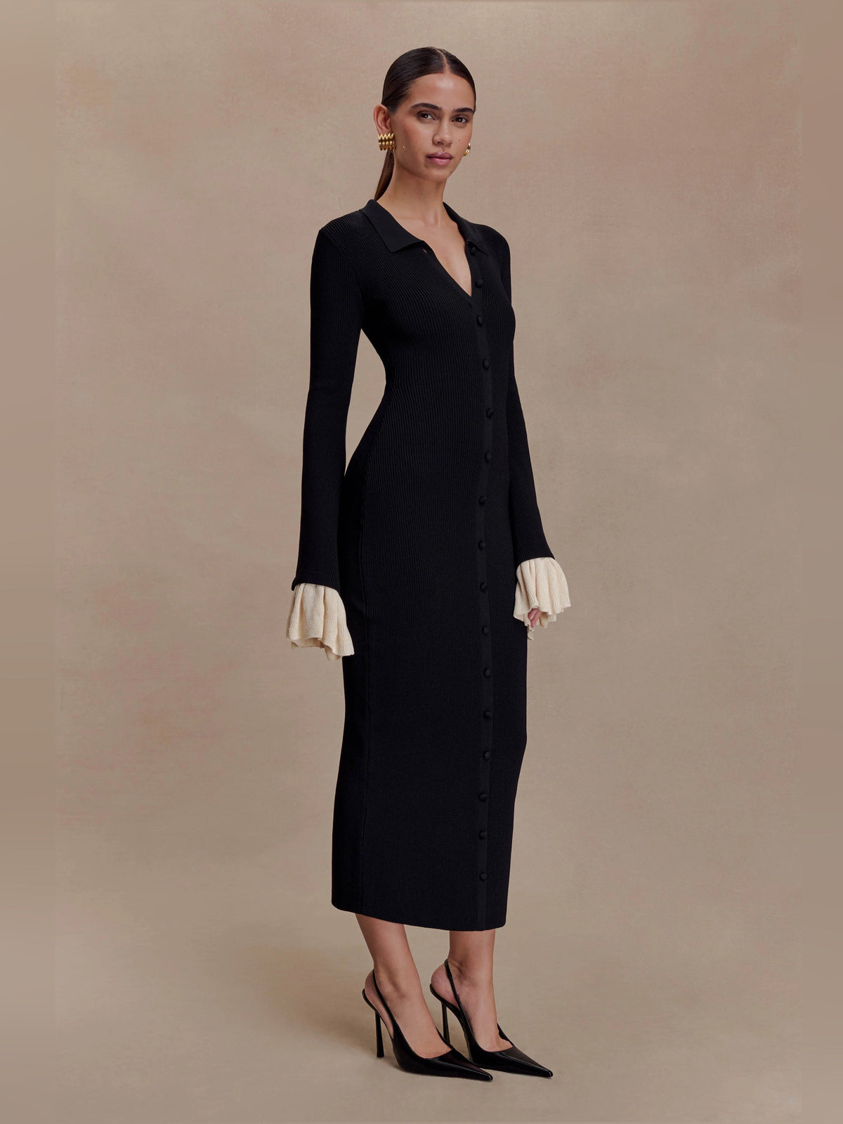 Amirose black knit midi dress, V-neck button front, side profile, cream ruffle cuffs