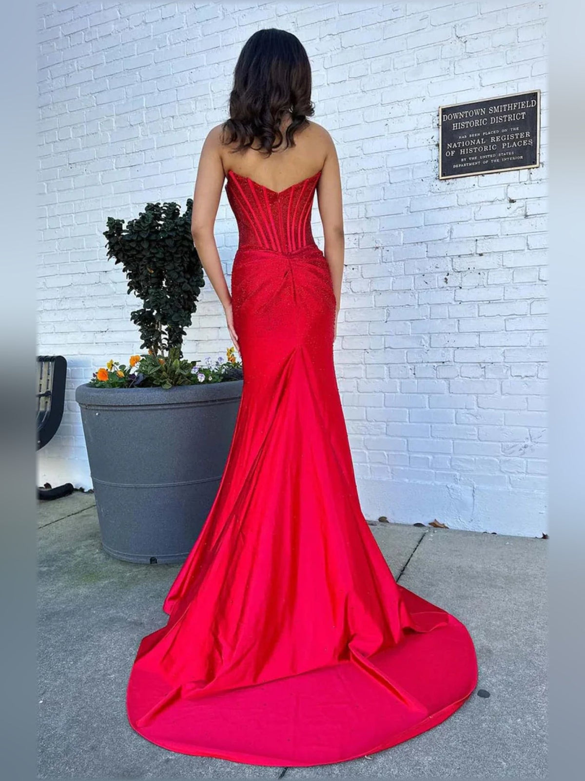 Red corset-style formal dress from the back with low back and sweeping train