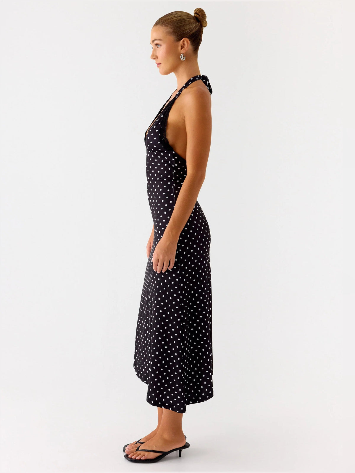Black polka-dot halter midi dress, side profile with open-back tie detail