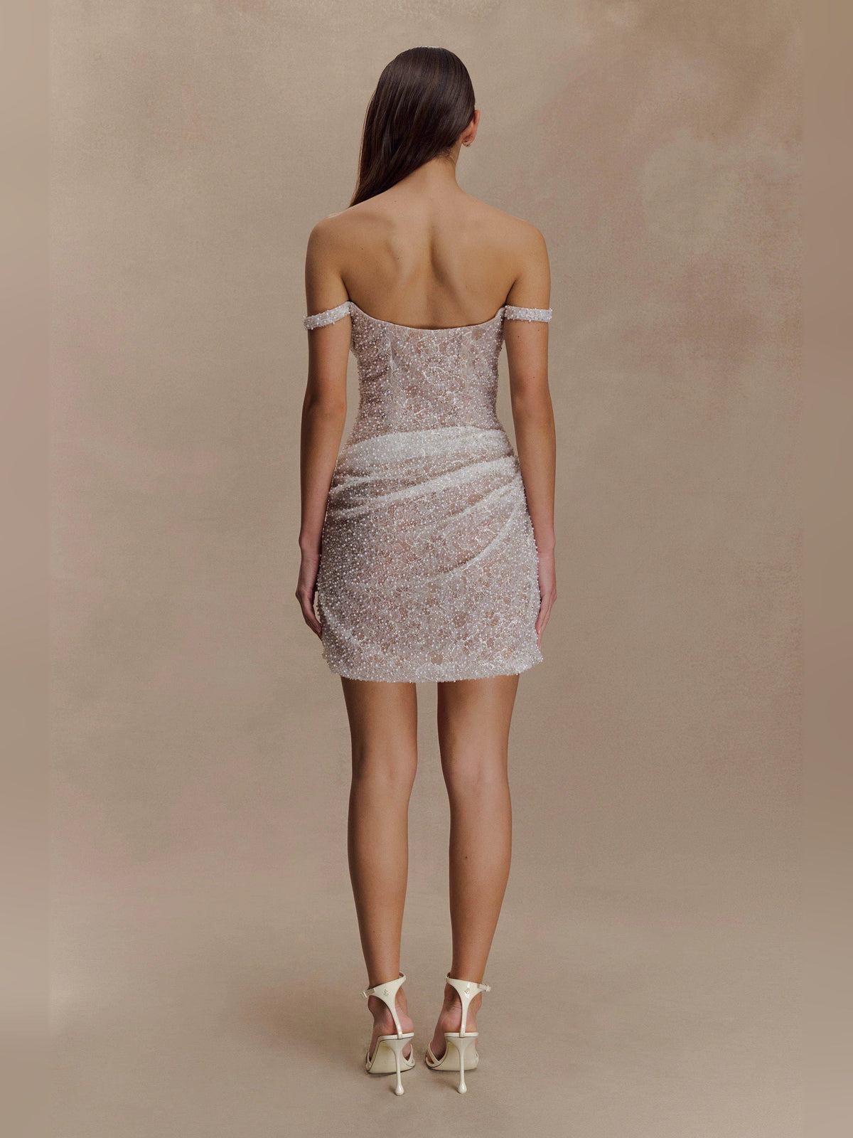 Back view of nude beaded off-shoulder bodycon mini dress with open back detailing