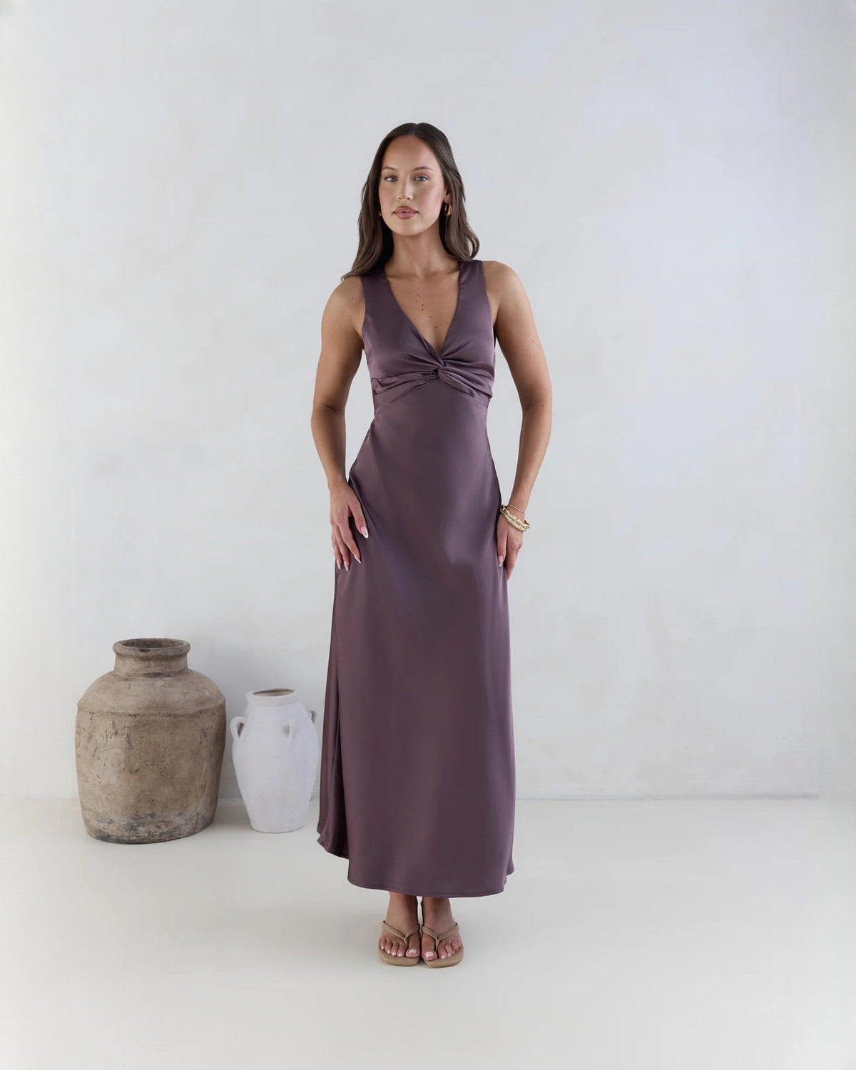 Purple satin sleeveless A-line maxi dress with V-neck twist bodice.