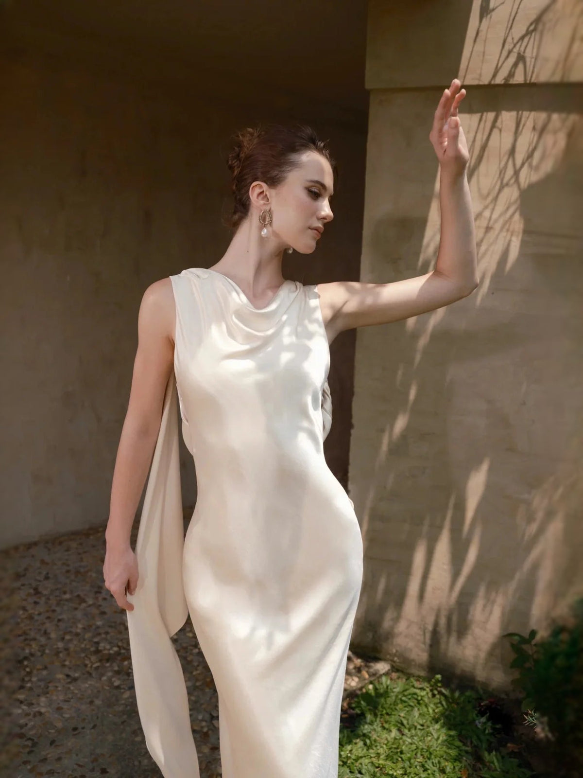 Ivory satin cowl-neck sheath wedding dress with draped neckline and open-back straps