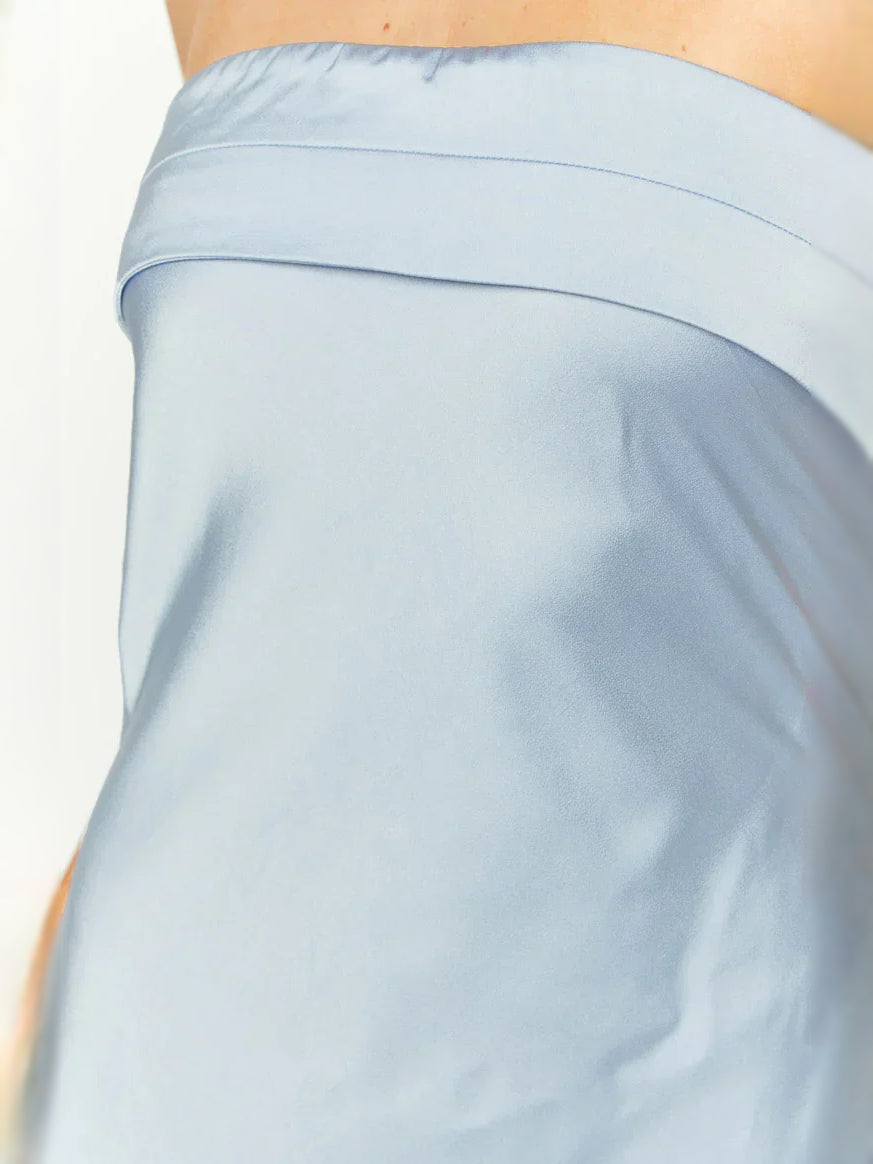 Light blue satin strapless dress fabric close-up with smooth neckline band