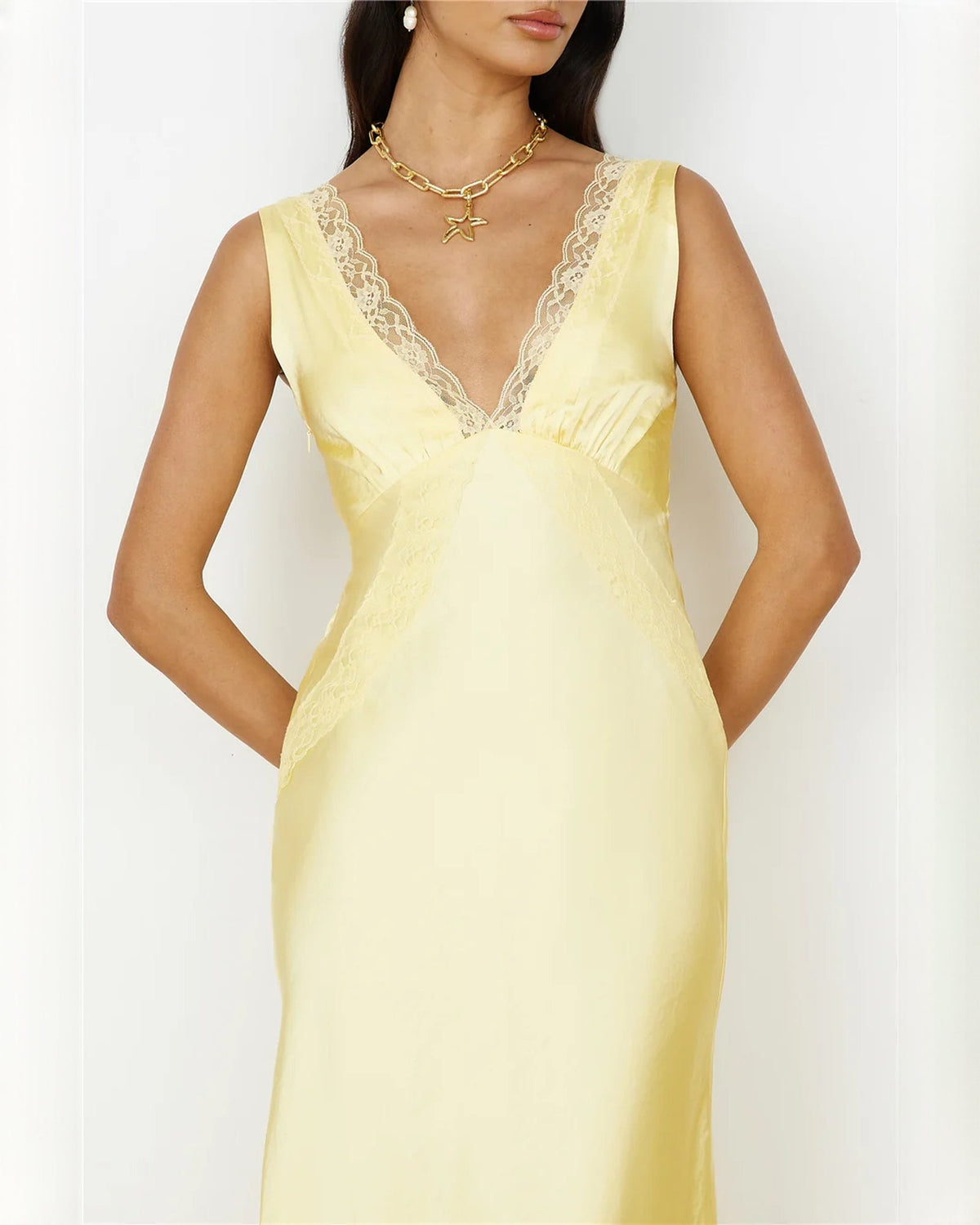 Light yellow satin maxi dress with lace-trim V-neck, sleeveless bodice, and gold necklace