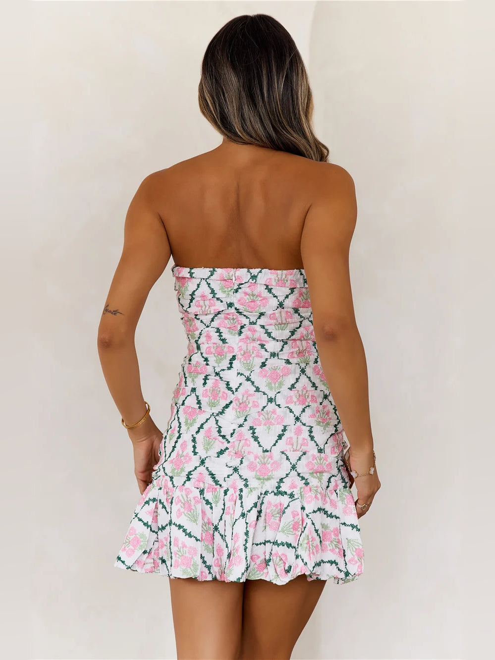 Back view of floral ruffled mini dress with strapless bodice and tiered skirt