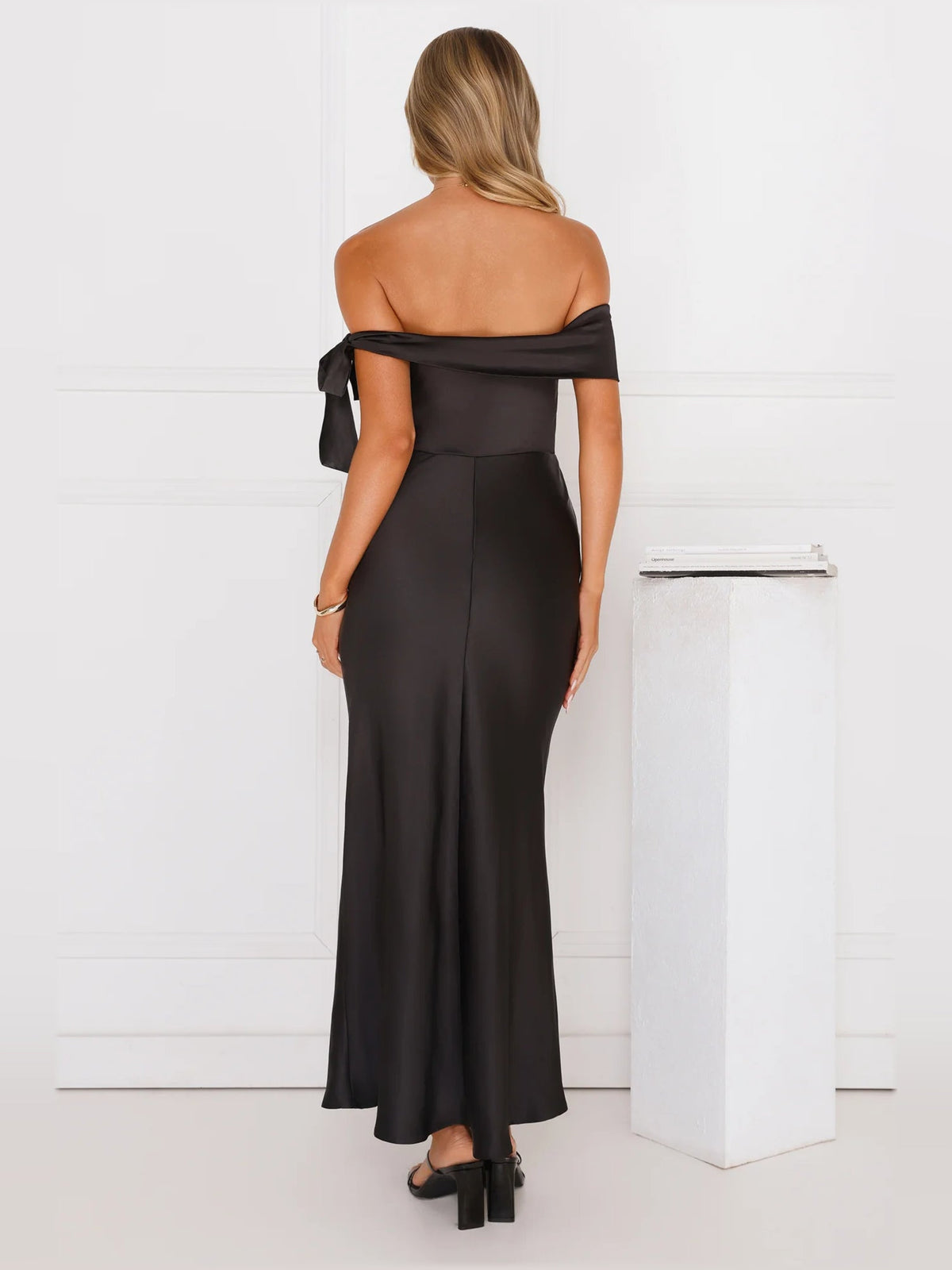 Black off-shoulder satin midi dress, back view with ribbon ties and open neckline