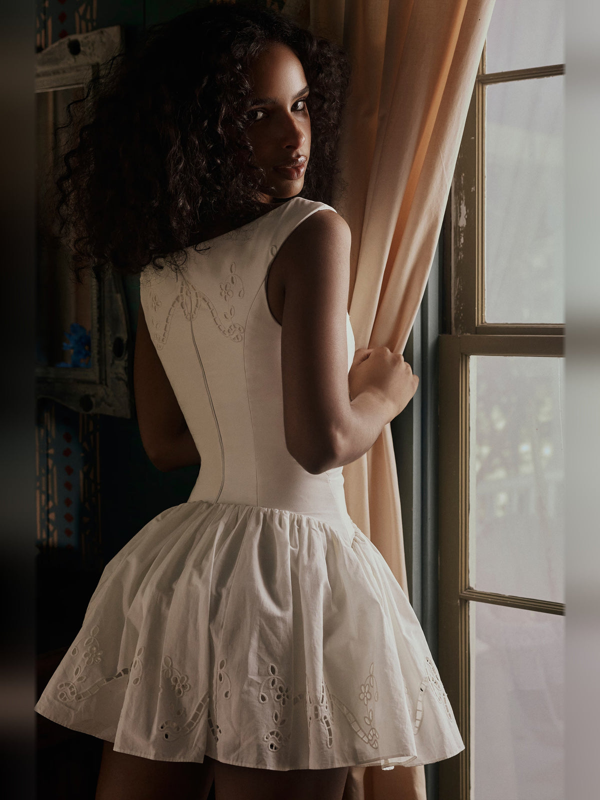 White sleeveless boat-neck mini dress with embroidered lace accents and gathered skirt