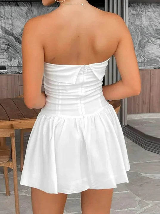 Back view of white off-shoulder strapless mini dress with ruched bodice and flared skirt