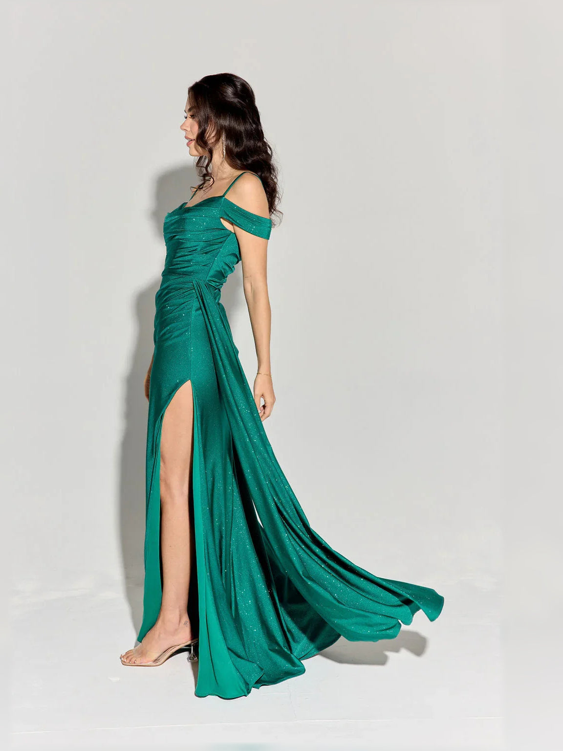 Green off-shoulder formal dress with ruched bodice and thigh-high slit, flowing maxi.