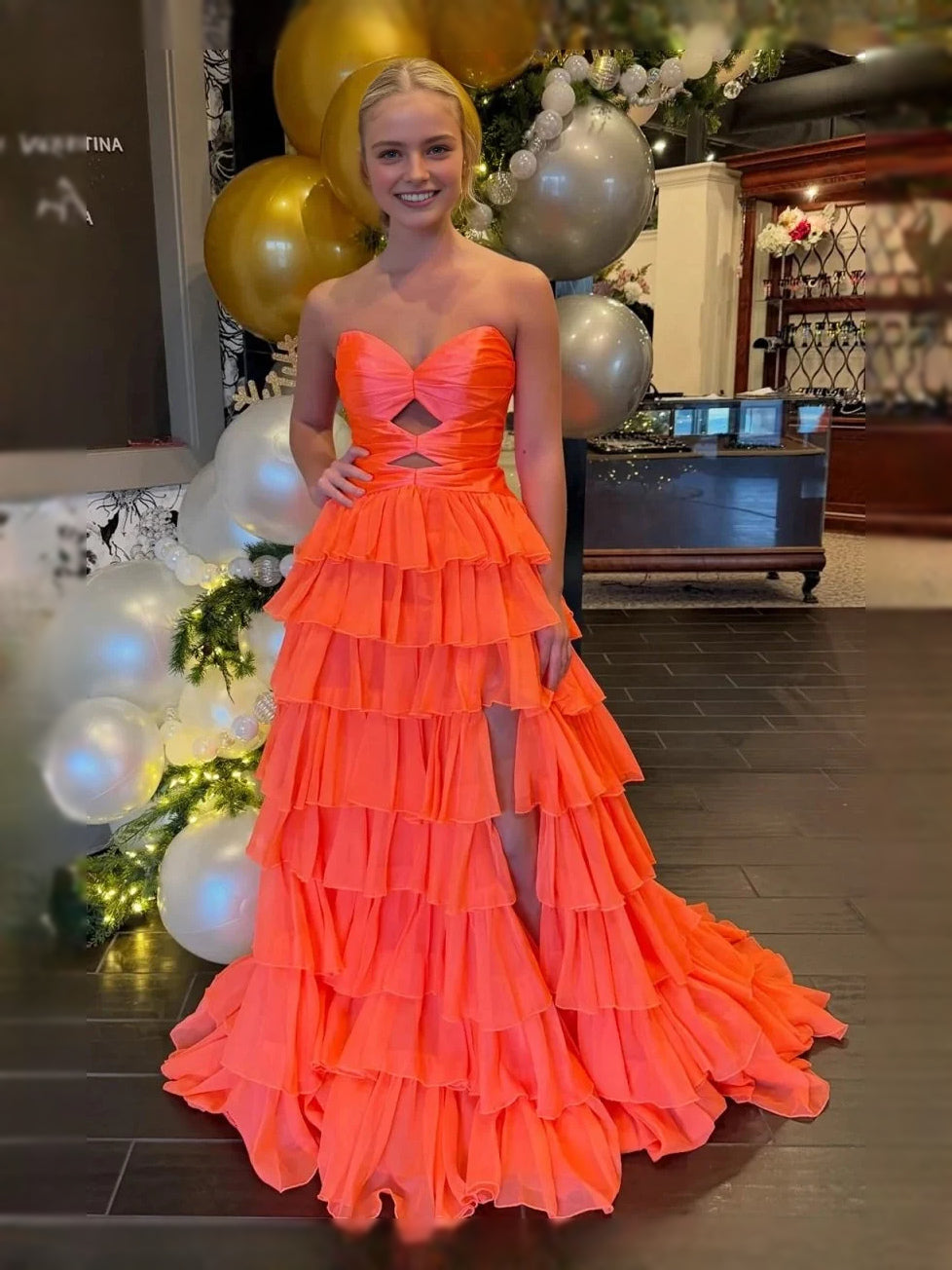Orange strapless sweetheart ruffle prom dress with tiered skirt and corset cut-out detail