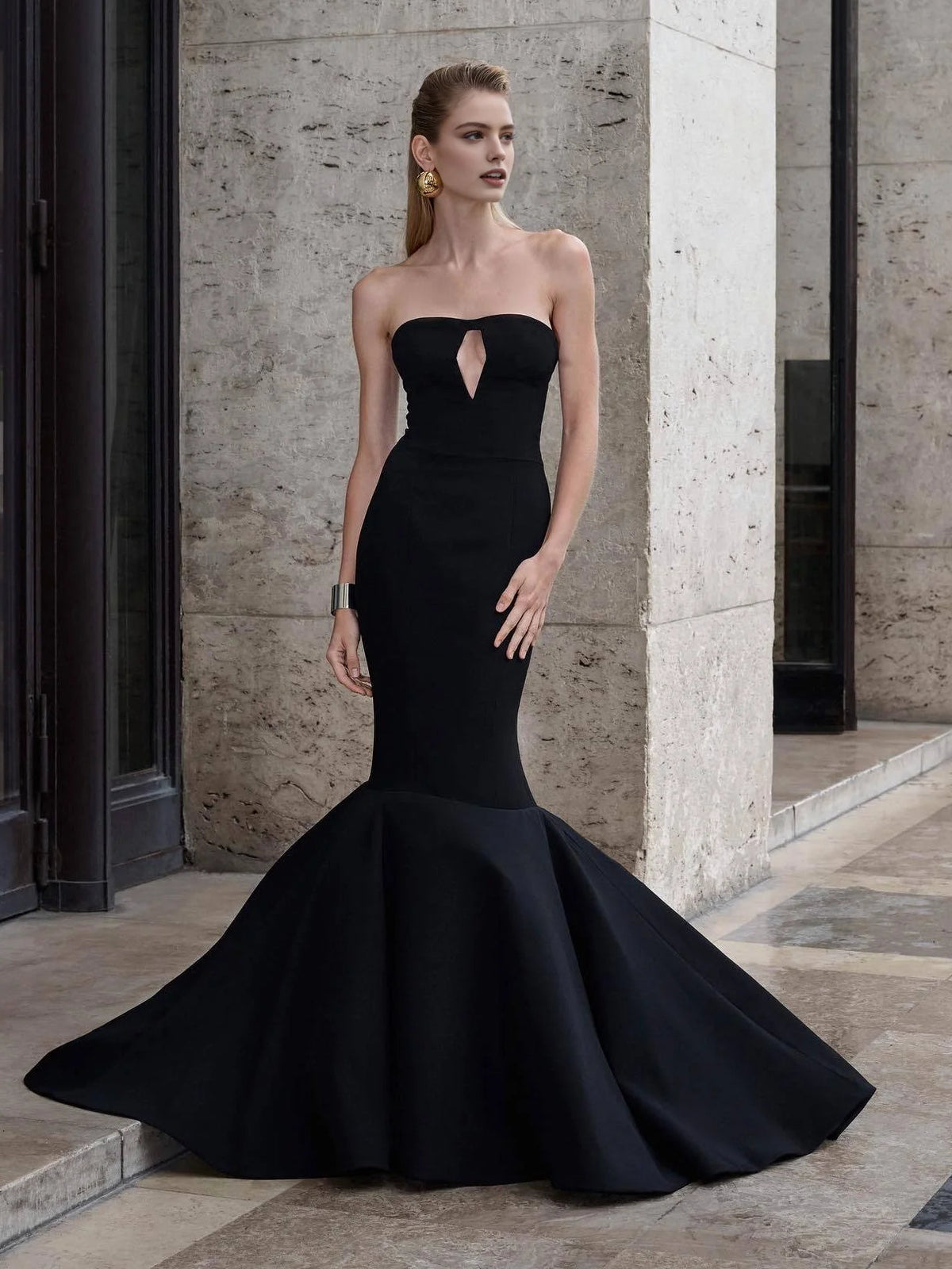 Black strapless formal gown with sweetheart neckline and chest cutout, dramatic flared skirt
