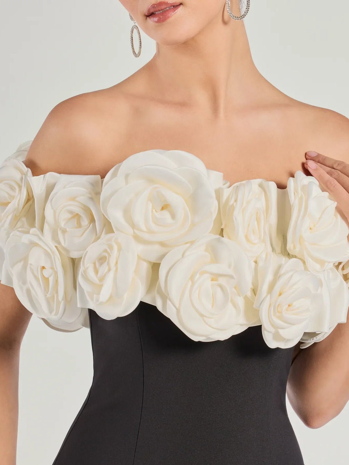 Off-shoulder bodice with cream rose rosette appliques and elastic neckline, close-up