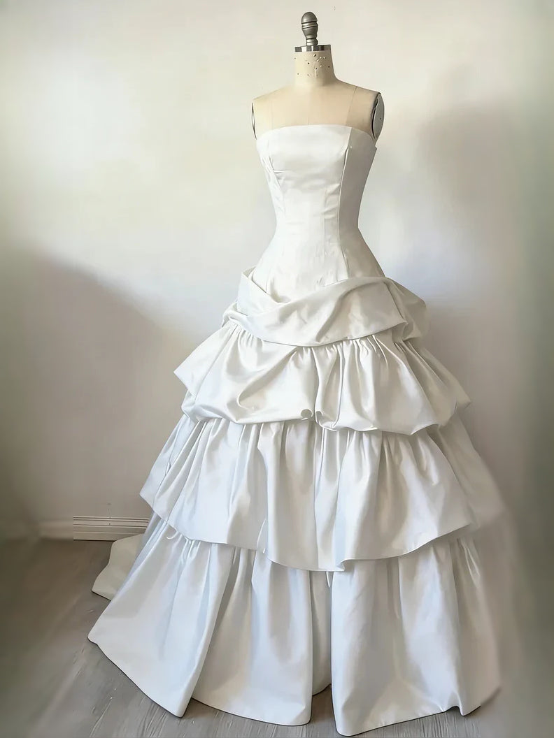 Ivory satin strapless corset ball gown with tiered ruffle skirt on mannequin