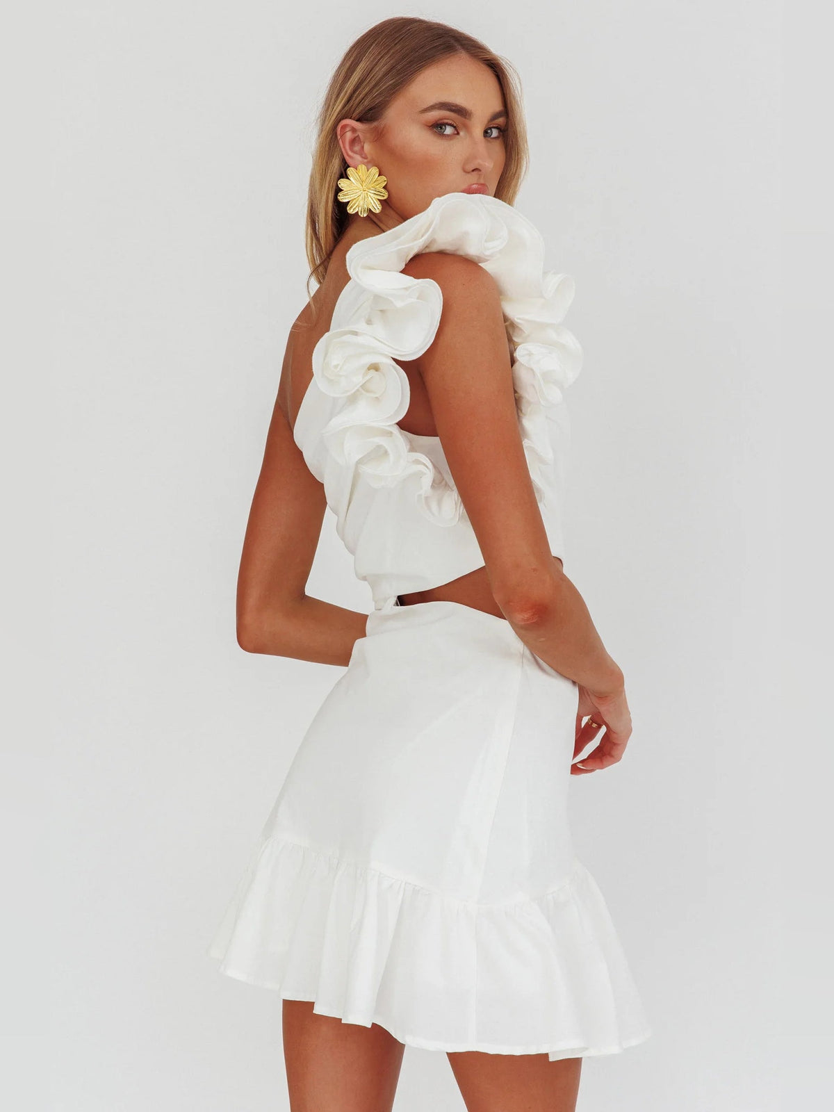 White one-shoulder mini dress with ruffle sleeve tiers and waist cut-out