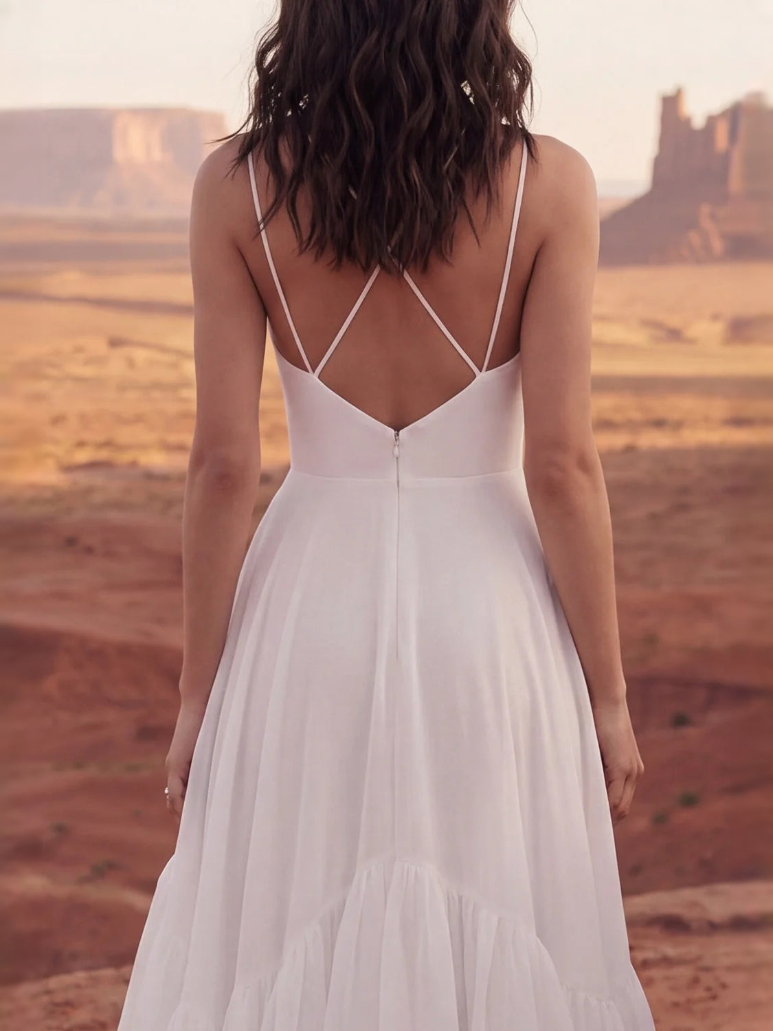 Ivory back view wedding dress with crisscross straps and tiered chiffon ruffle skirt