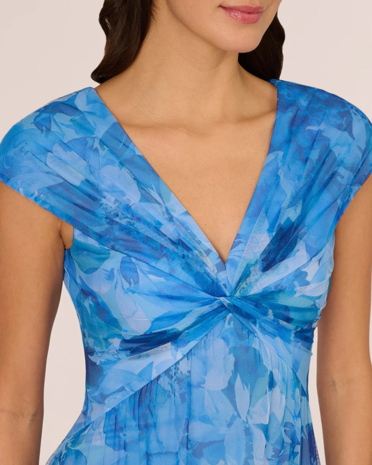 Close-up of blue floral V-neck cap-sleeve dress with ruched twisted front