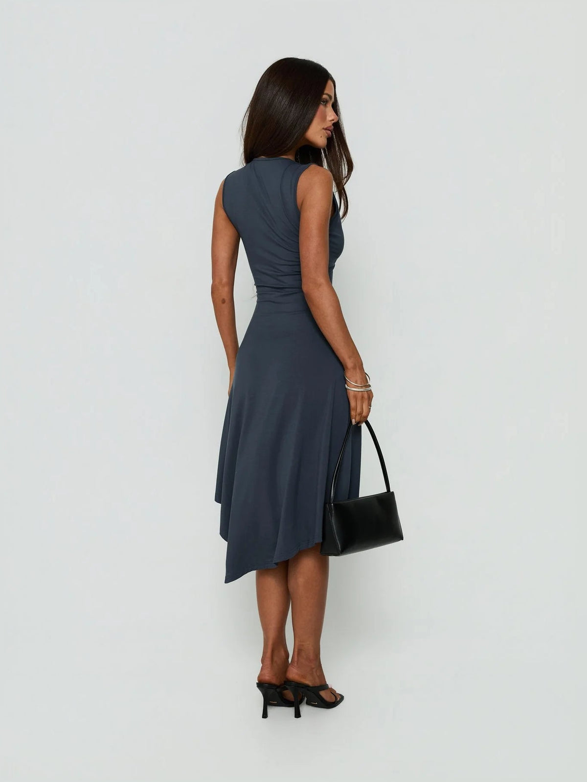 Back view of sleeveless V-neck midi dress with draped hanky hem and asymmetrical back