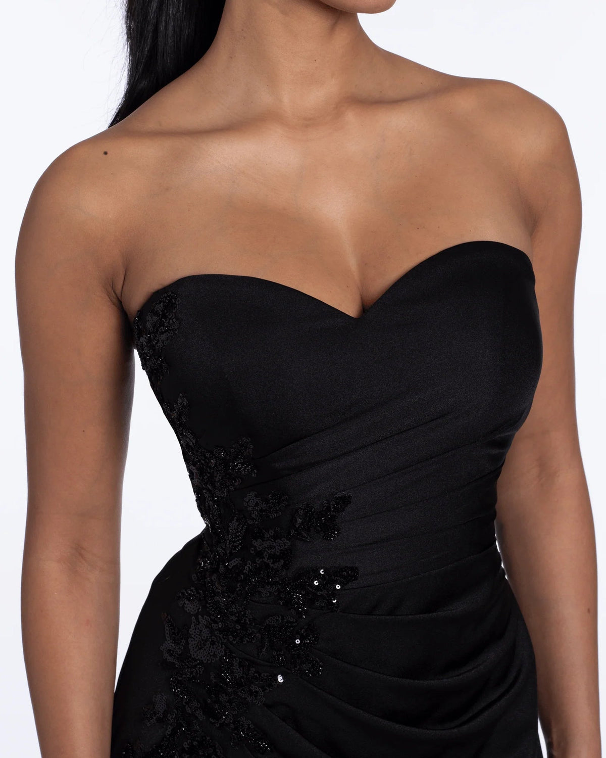 Close-up of black strapless sweetheart bodice with ruched fabric and sparkling embellishments