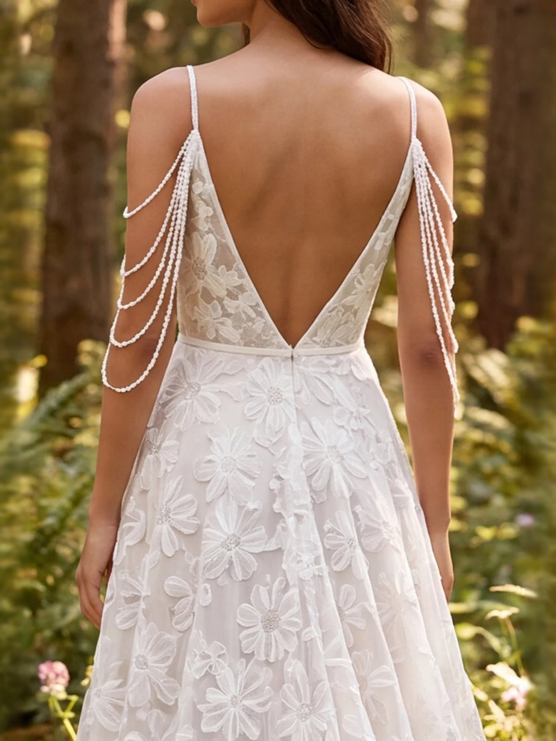 Ivory backless wedding dress with V-back, floral applique, and beaded strap chains