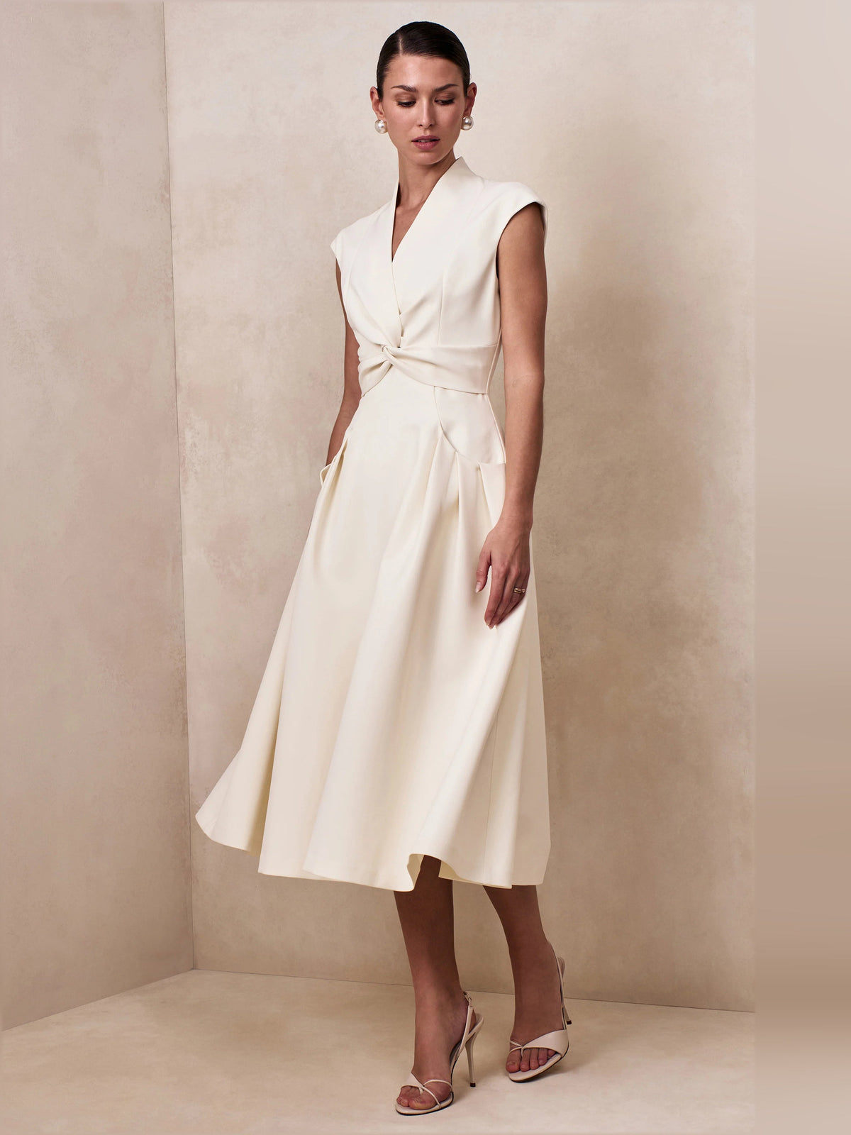 Cream V-neck sleeveless midi dress with twisted waist tie and A-line skirt