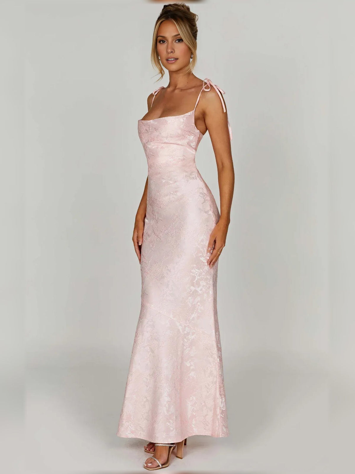 Blush pink floral formal dress with thin straps and fitted bodice, floor-length