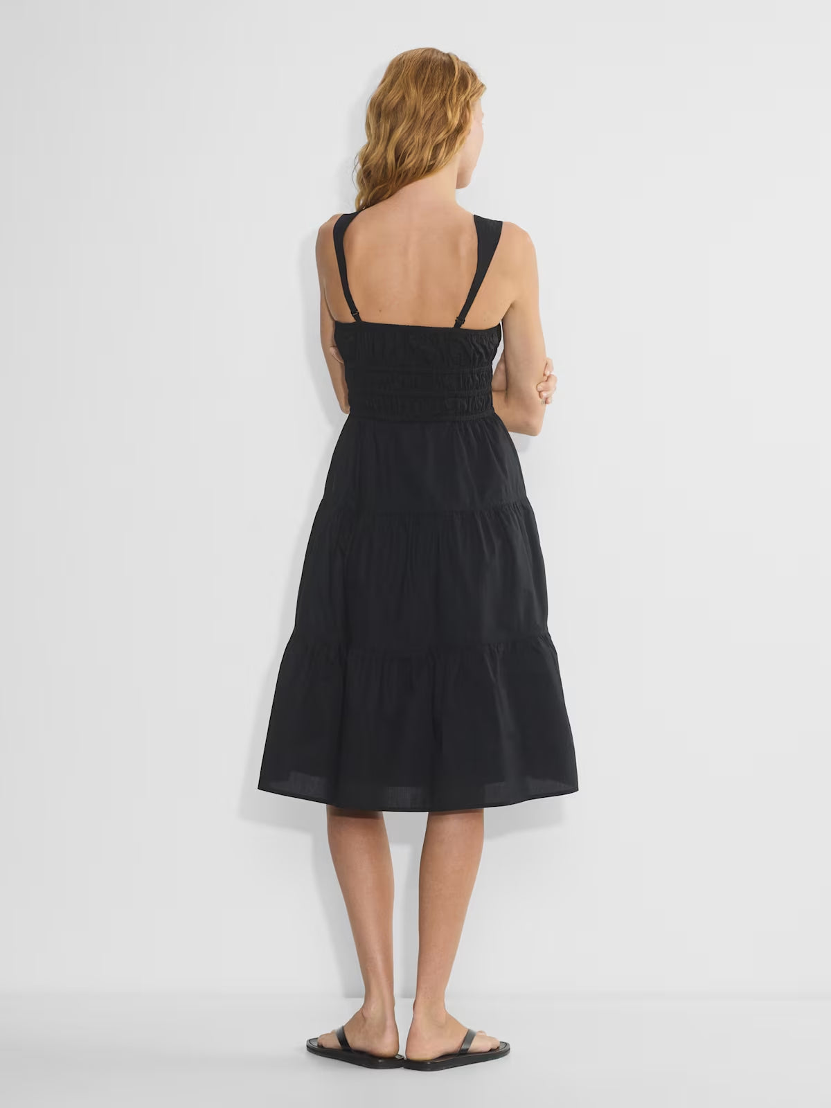 Black tiered midi dress, back view with spaghetti straps and gathered smocked waist