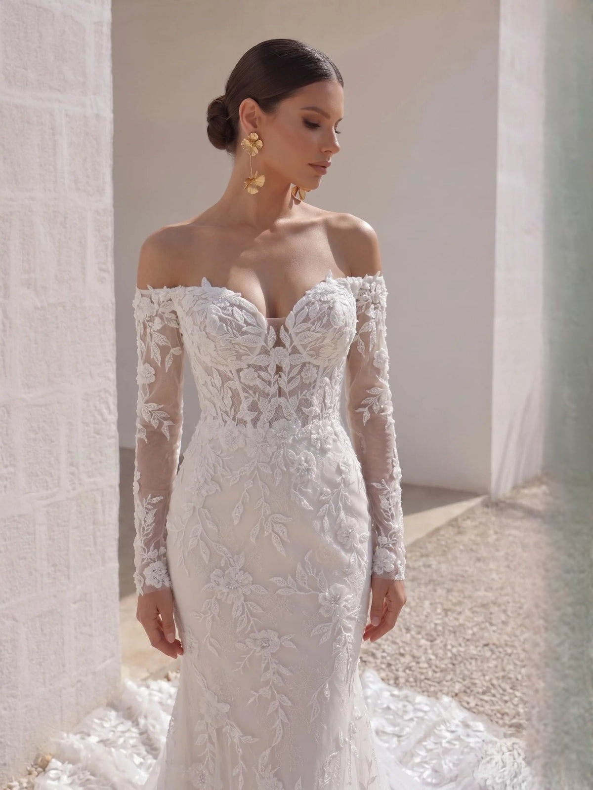 Ivory corset-style mermaid wedding dress with lace off-shoulder neckline and floral detailing