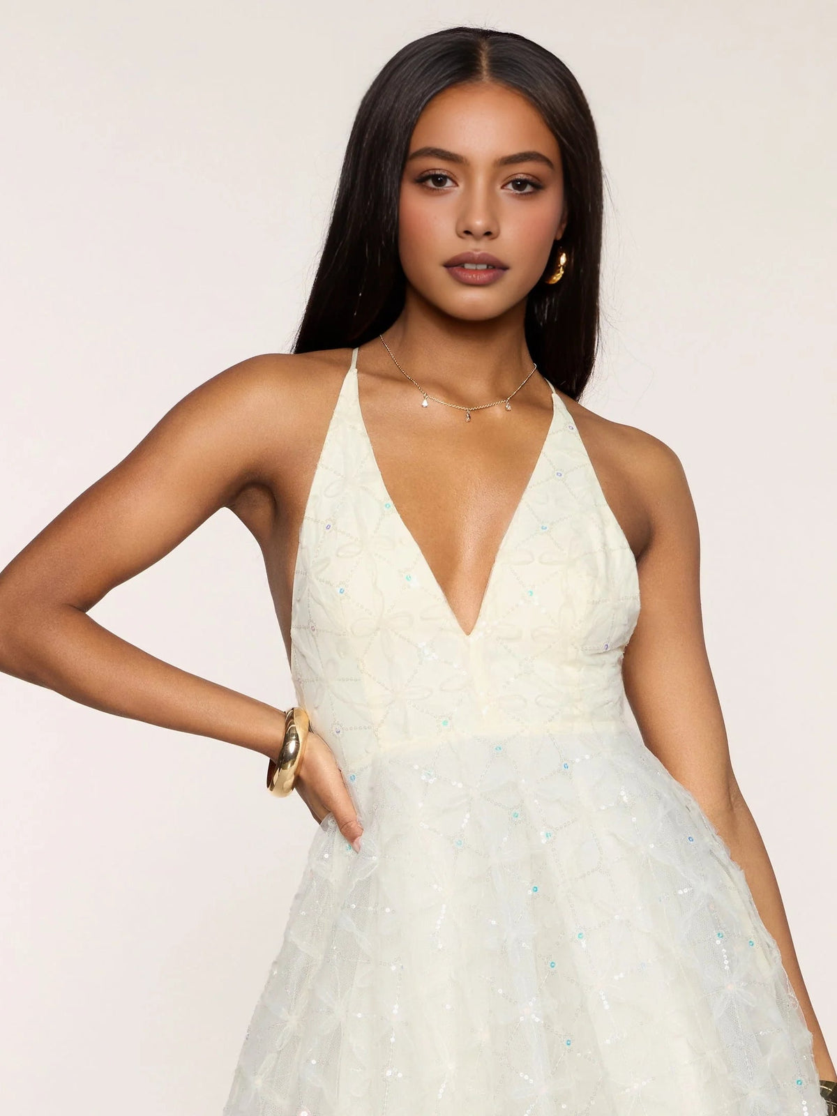 Ivory V-neck tulle mini dress close-up with thin straps and sequin floral embroidery