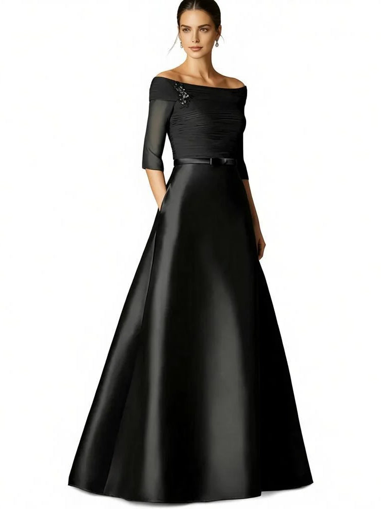 Black satin A-line off-shoulder dress with ruched bodice, 3/4 sleeves, and waist belt
