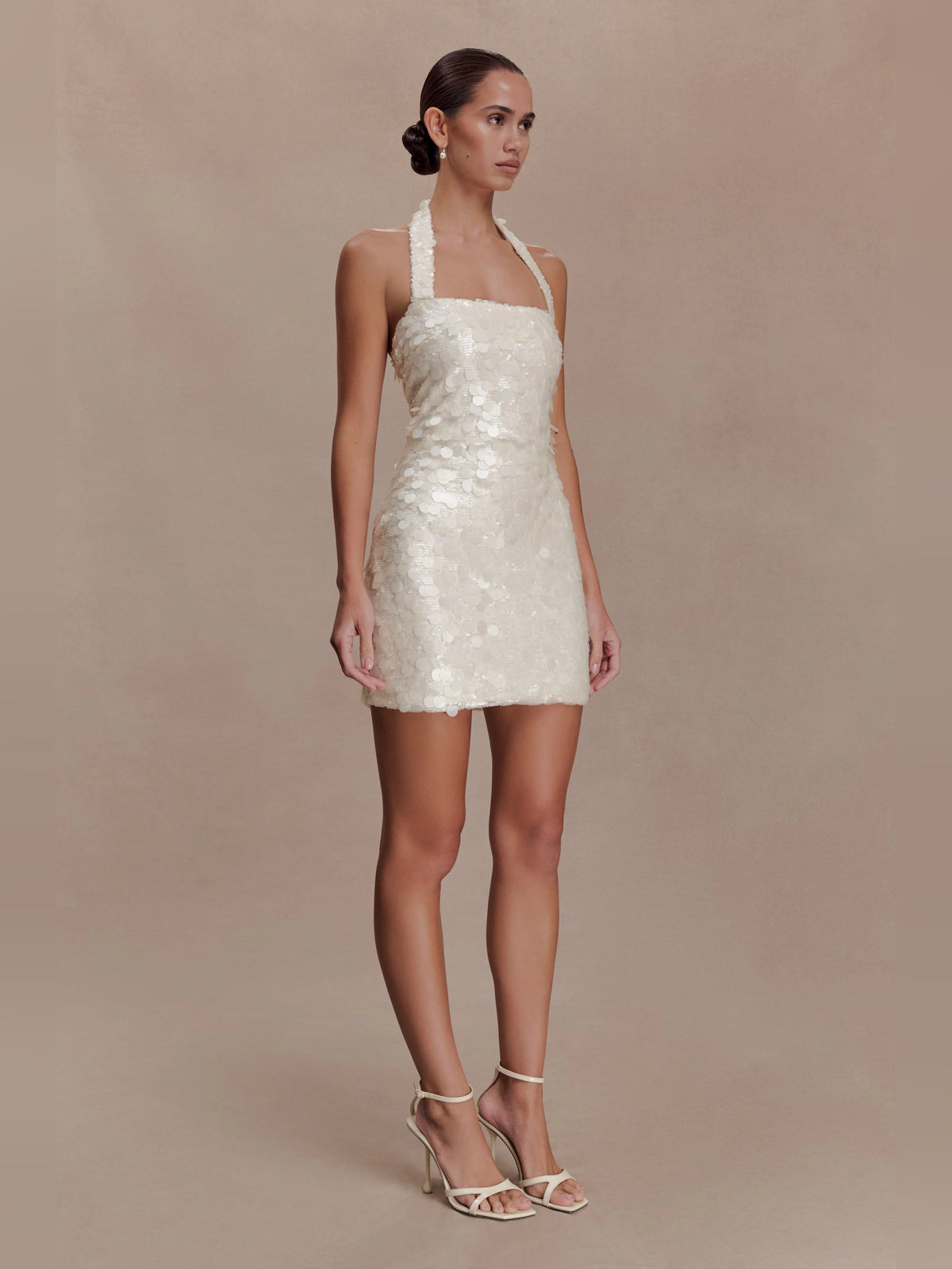 Ivory sequin halter-neck mini dress with thin straps, fitted waist, and straight hem