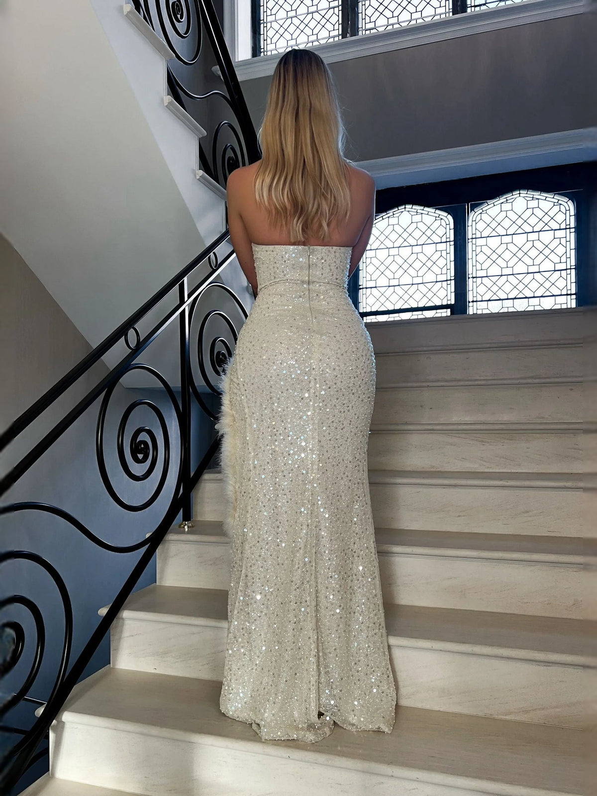 Cream beaded floor-length sheath dress, back view with feather hem