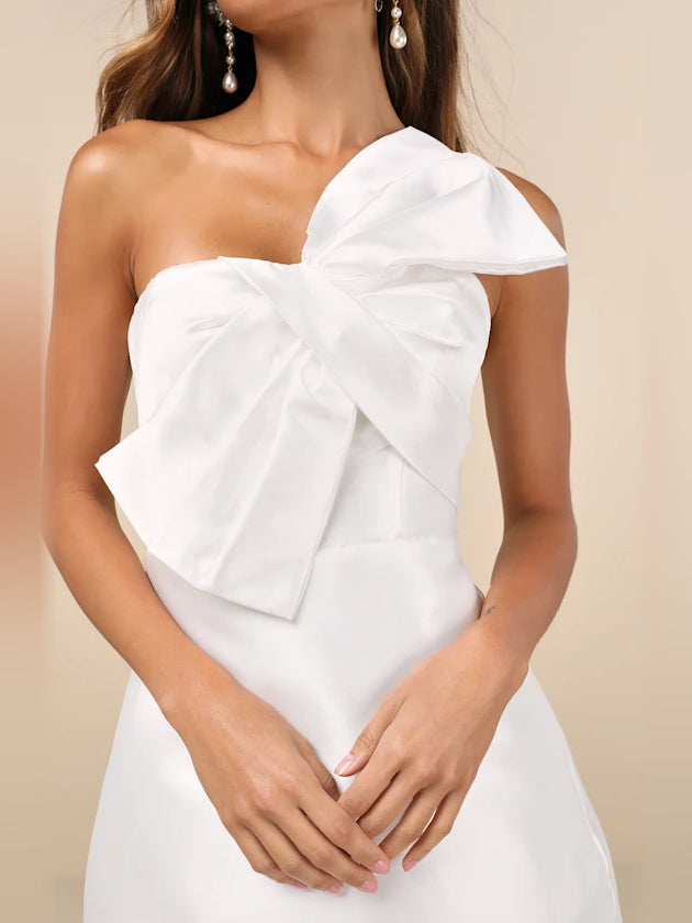 White one-shoulder bodice with oversized fabric bow and layered ruffle accent