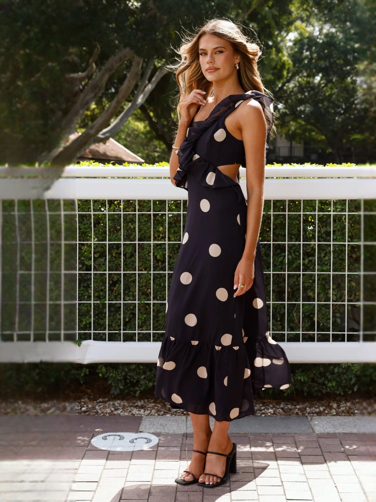 Black polka-dot midi formal dress with sleeveless ruffle bodice and tiered skirt