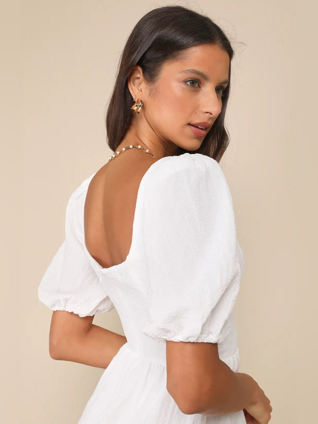 White wrap mini dress with puff sleeves and open back scoop