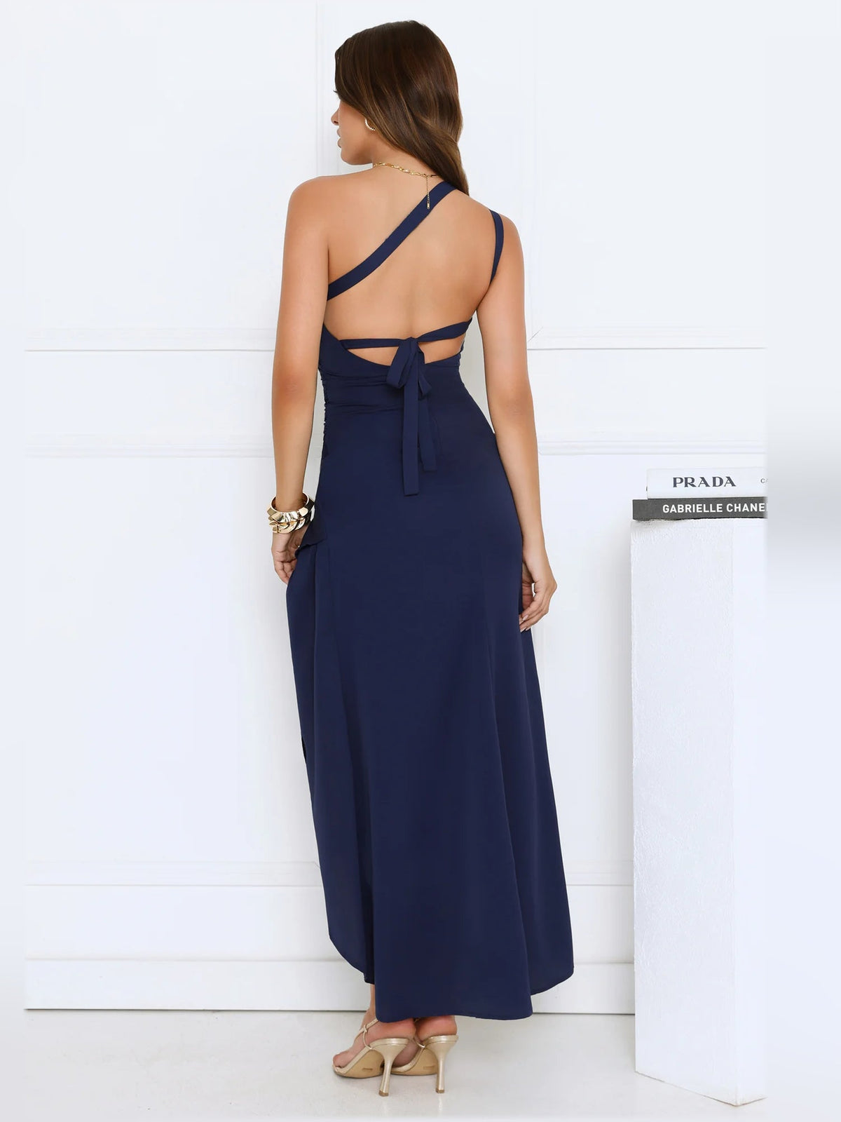 Navy one-shoulder midi formal dress back view with crisscross straps and drape