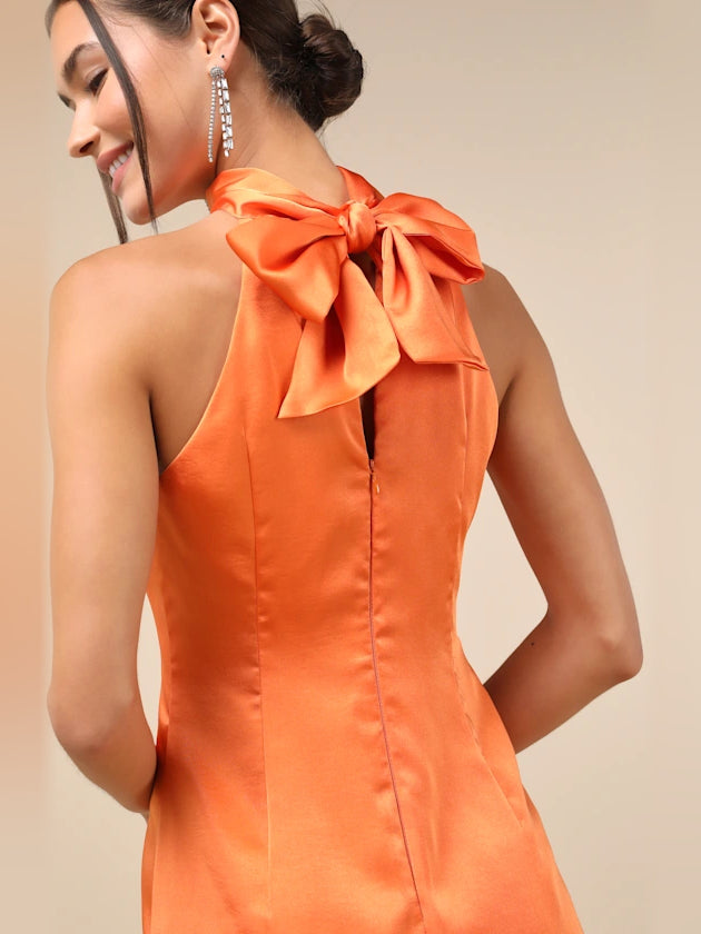 Orange satin open-back mini dress with oversized tied bow at the neck