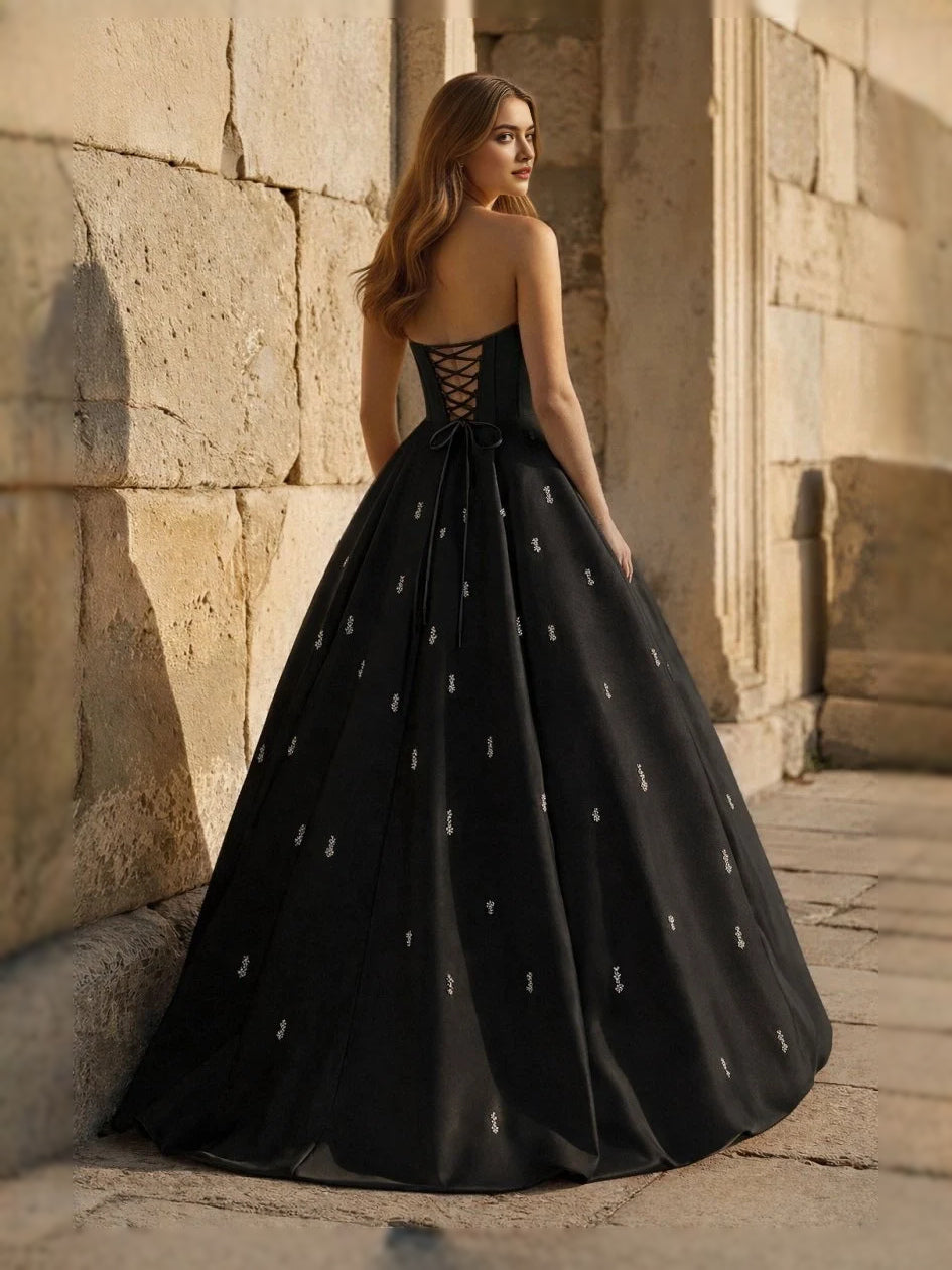 Black sweetheart corset ball gown with thin straps and full floor-length skirt, side view