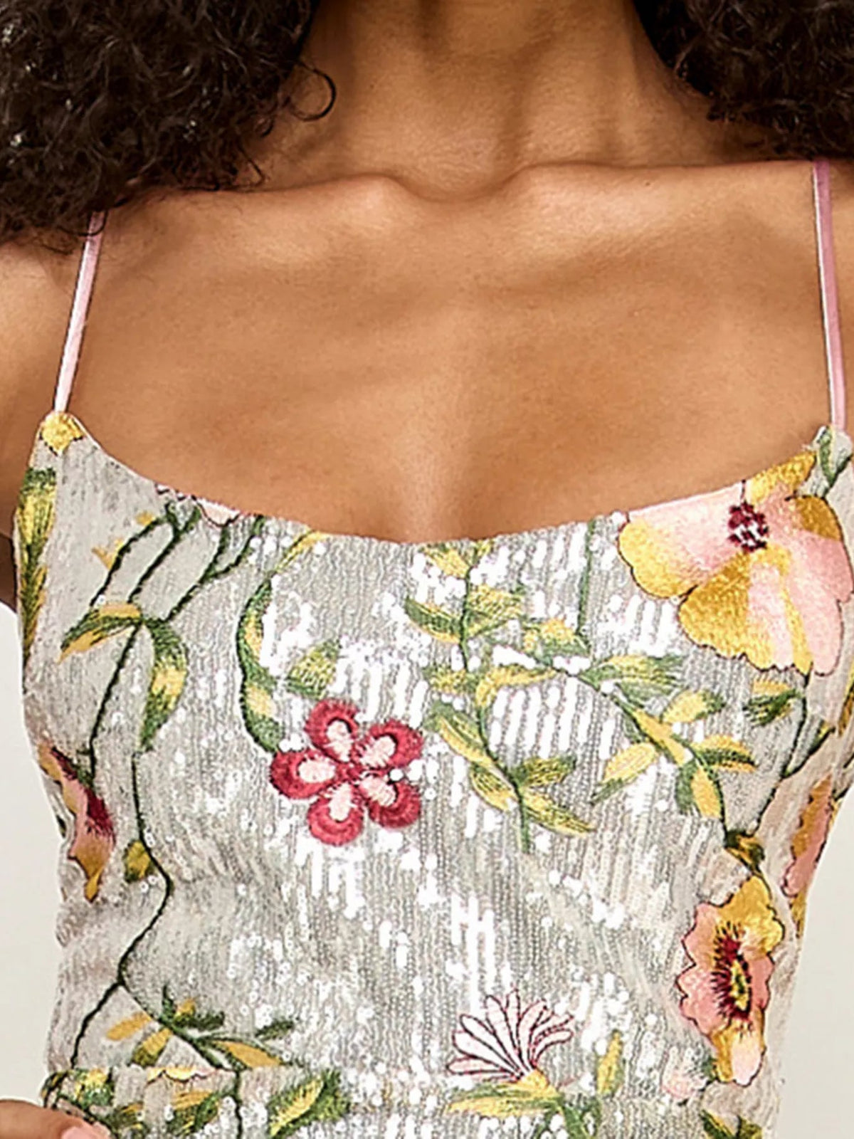 Close-up of embroidered scoop-neck formal dress with thin spaghetti straps and floral pattern