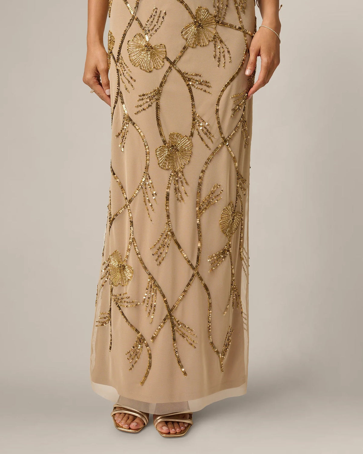 Gold beaded floral pattern on champagne maxi dress with A-line skirt and slit