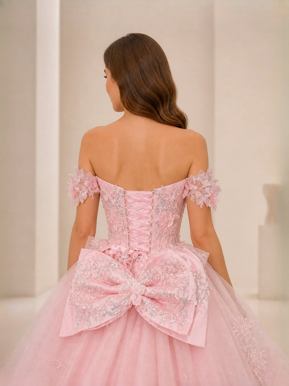 Pink off-shoulder backless tulle ball gown with bow at waist and floral appliques