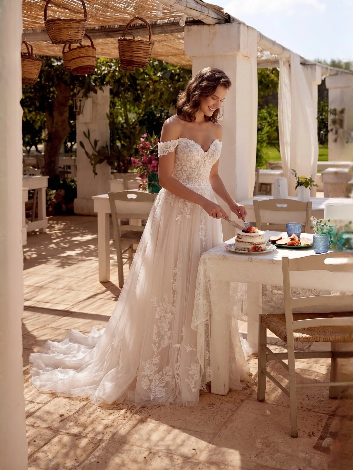 Ivory off-shoulder wedding gown with floral lace bodice and layered tulle skirt
