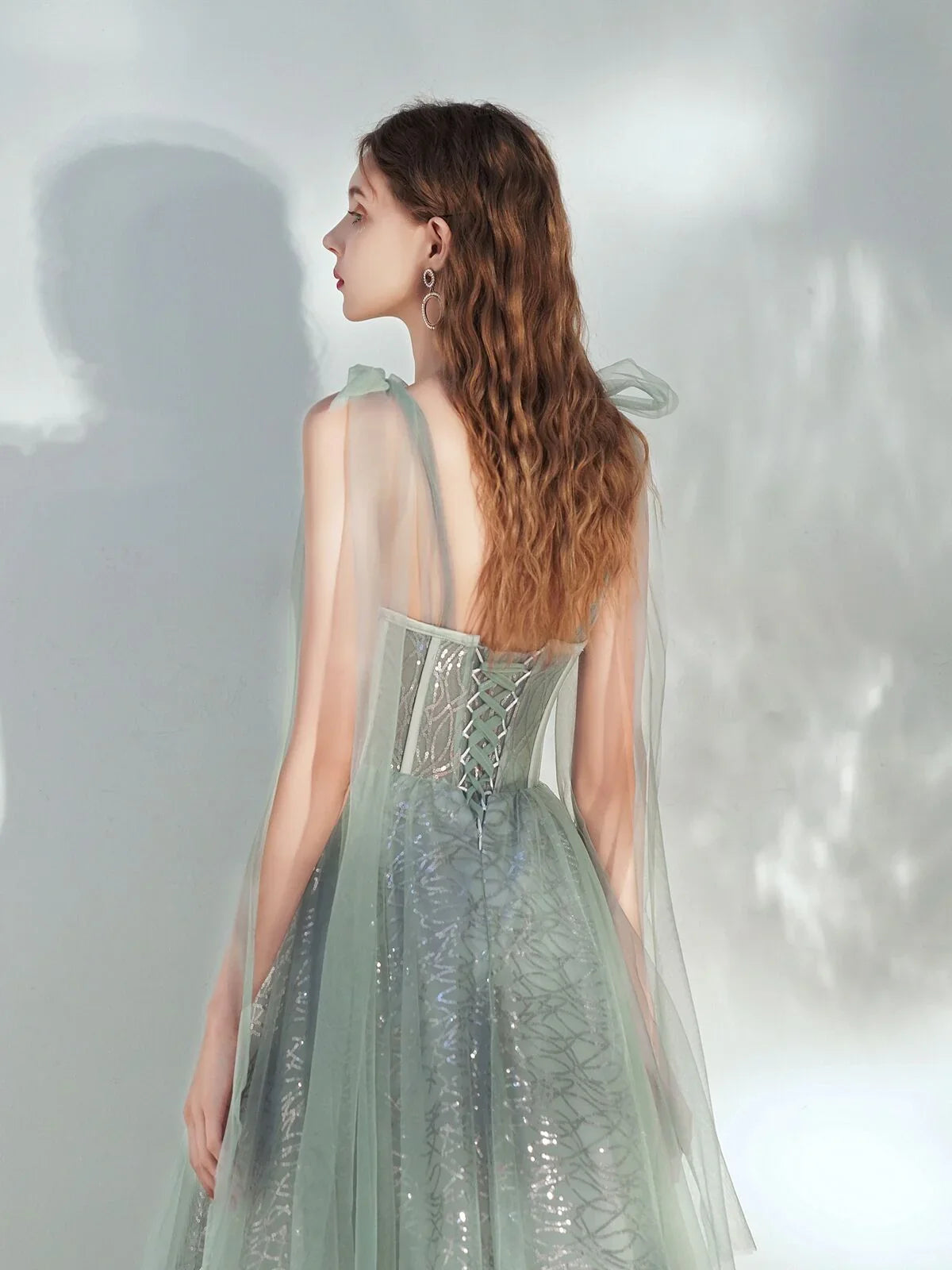 Back view of sweetheart corset A-line midi dress in sage green with sheer open back