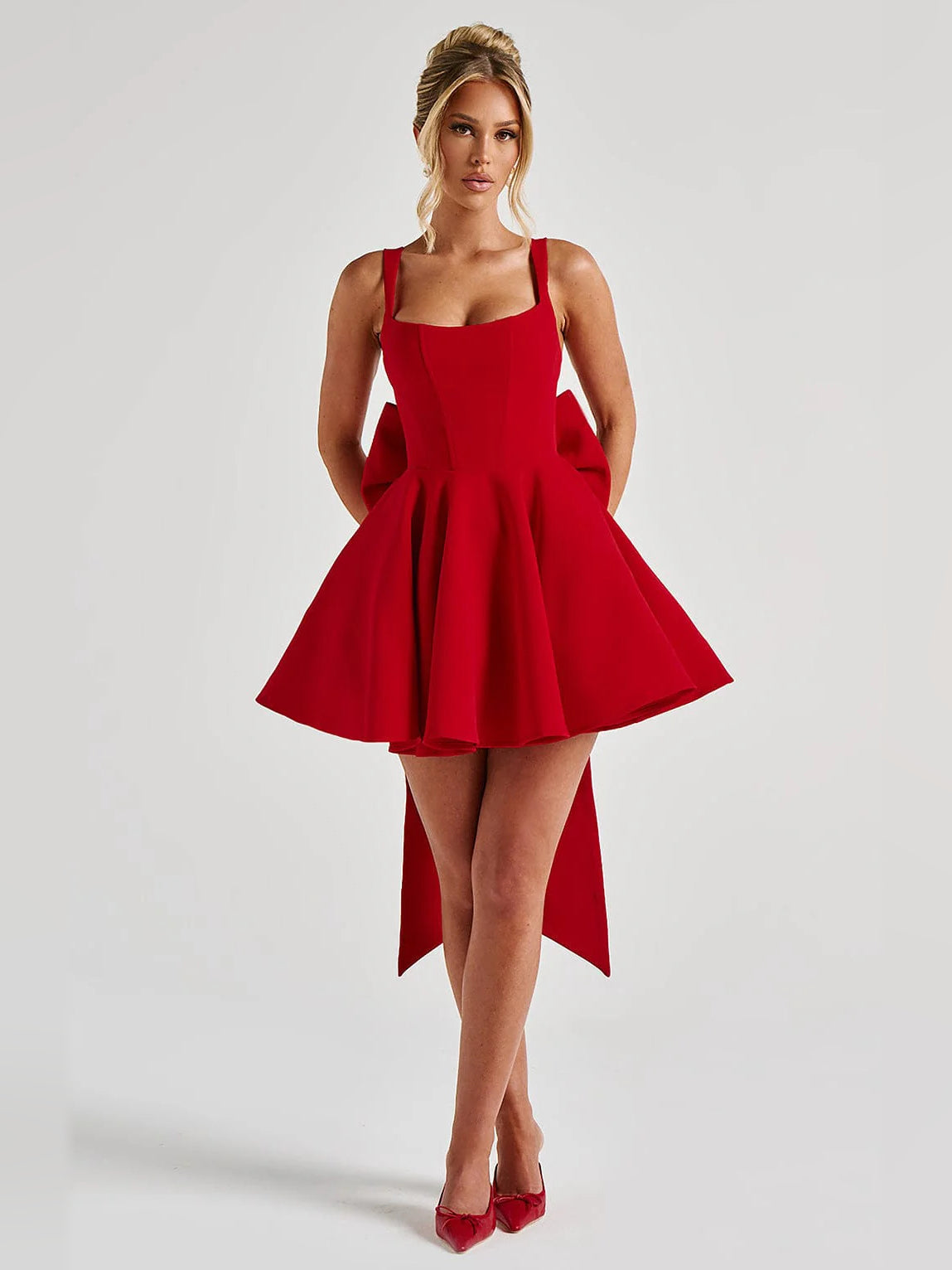 Red sleeveless mini homecoming dress with square neckline, flared skirt, and side slit tails