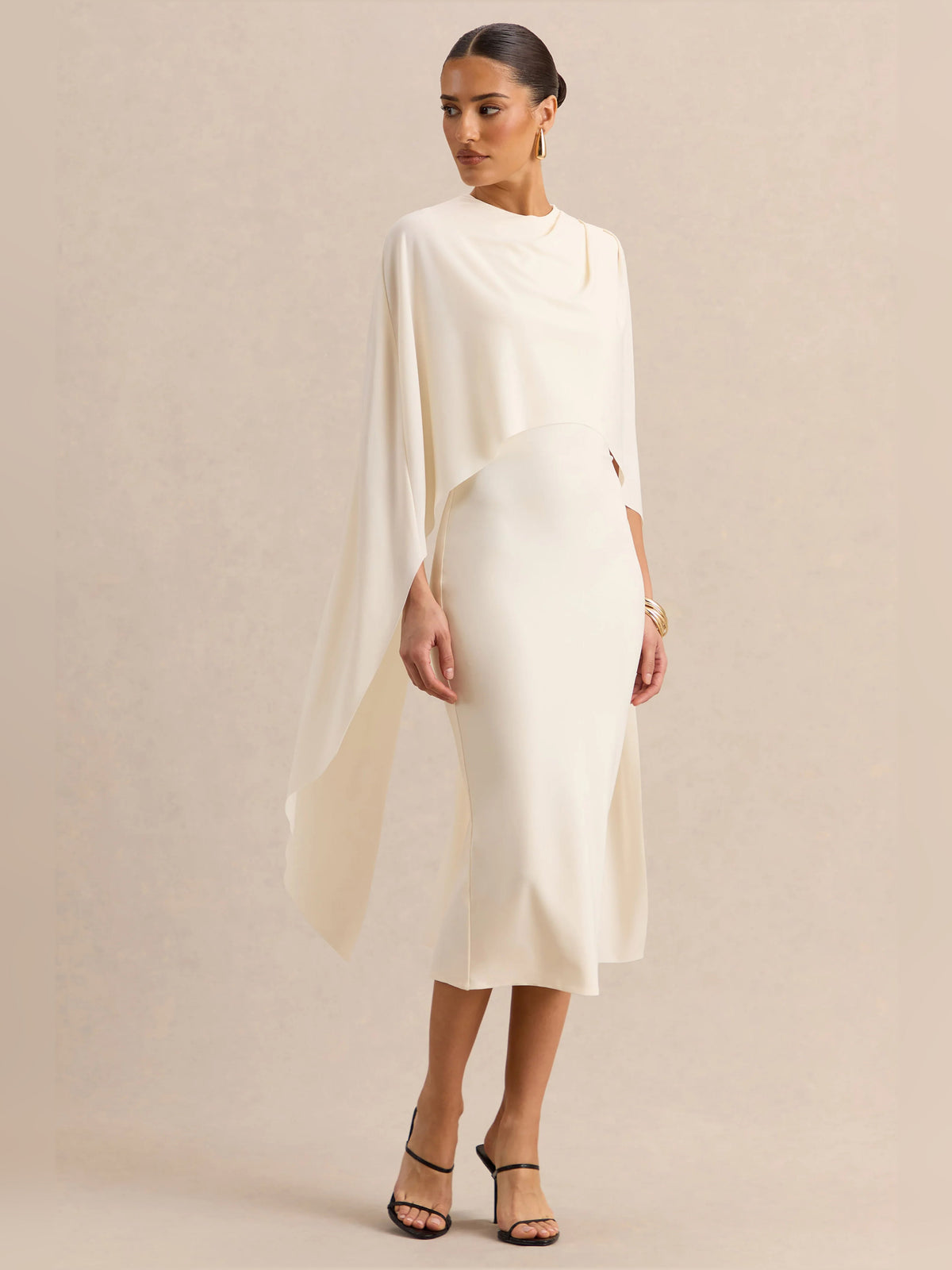 Cream midi formal dress front three-quarter view with cape sleeves and pencil silhouette