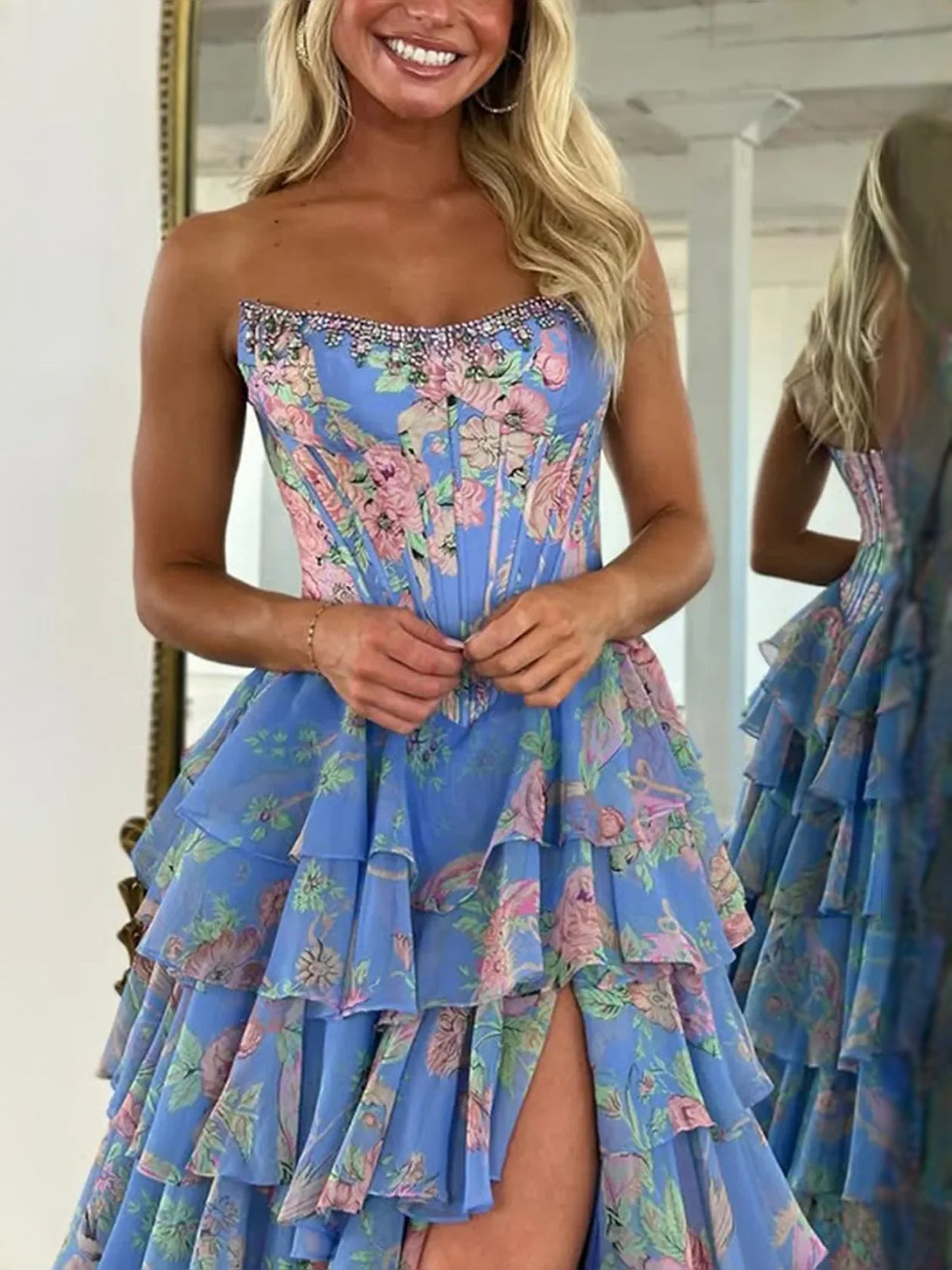 Blue floral strapless corset-style prom dress with tiered ruffle layers and open slit.