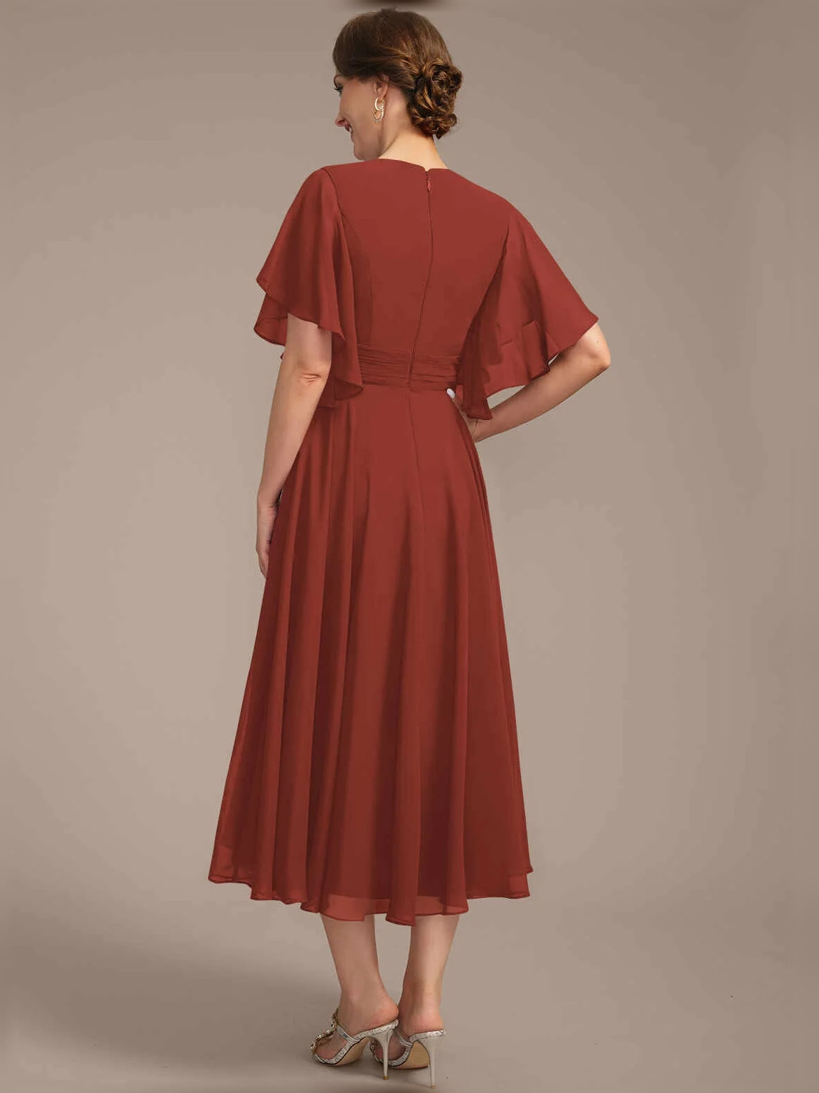 Back view of V-neck A-line chiffon dress with draped waist and pleated skirt, rust red