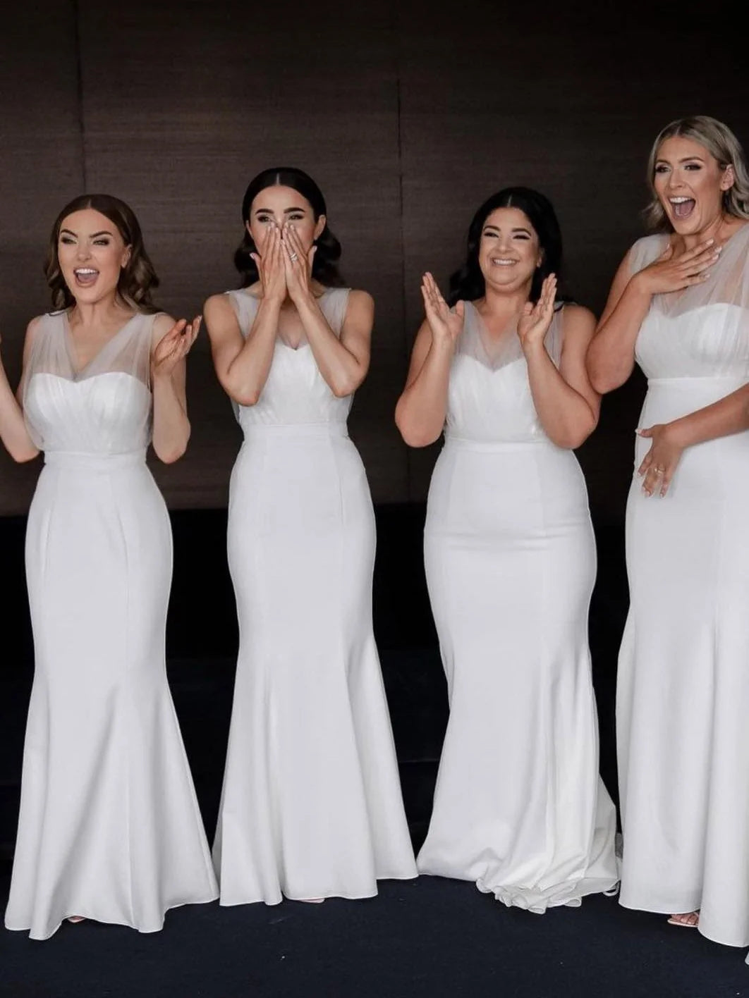 White sleeveless fitted maxi dresses worn by women posing in line